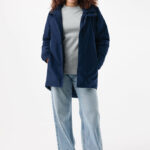 Femme portant veste bleue et jean clair.