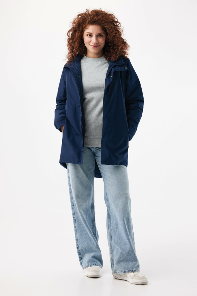 Femme portant veste bleue et jean clair.