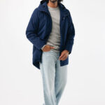 Homme souriant portant un manteau bleu et jean clair