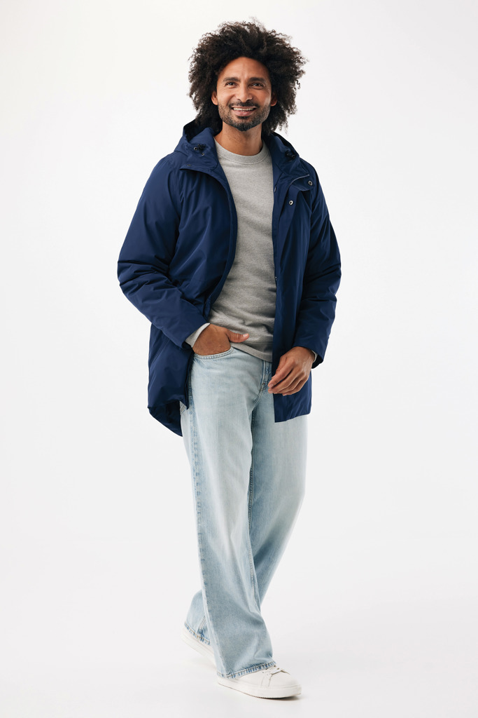Homme souriant portant un manteau bleu et jean clair