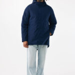 Homme portant une parka bleue et un jean clair