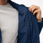 Homme montrant la doublure d’une veste bleue