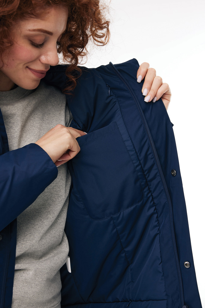 Personne montrant la poche intérieure d'une veste bleue