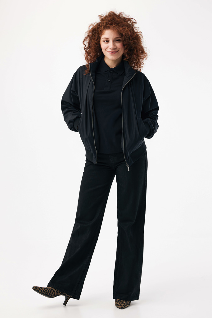 Femme souriante portant une tenue noire décontractée