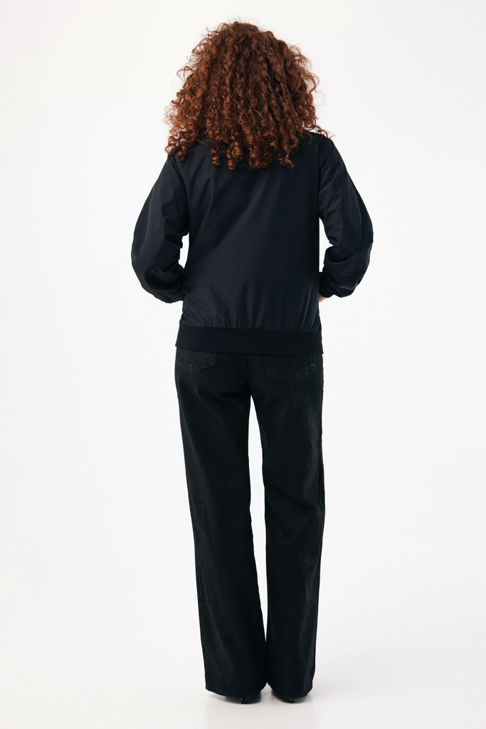 Personne portant veste noire et jean noir vue dos