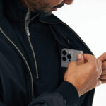 Homme range un smartphone dans sa poche intérieure