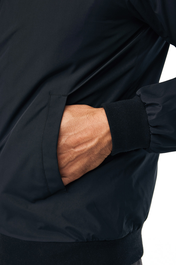 Main dans la poche d'une veste noire