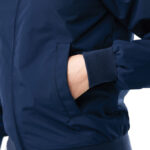 Main dans la poche d’un blouson bleu marine