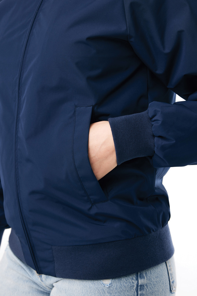 Main dans la poche d’un blouson bleu marine