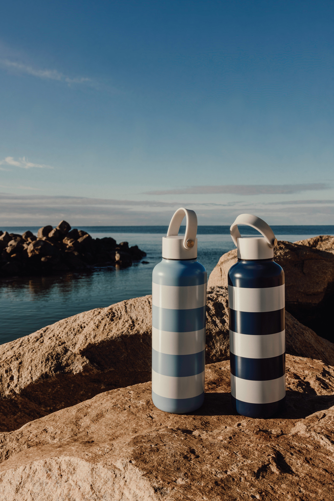 Deux bouteilles rayées sur un rocher en bord de mer