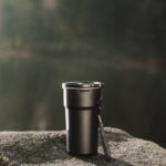 Gobelet isotherme noir sur un rocher en nature