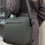 Sac bandoulière vert porté sur manteau gris