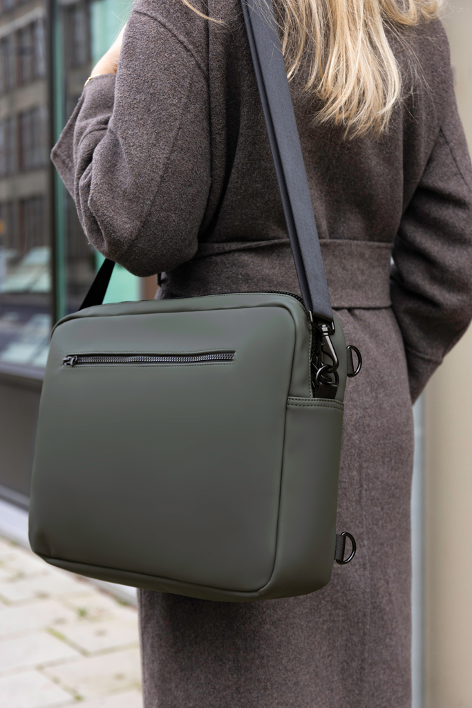 Sac bandoulière vert porté sur manteau gris