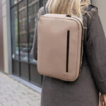 Femme portant un sac à dos beige moderne