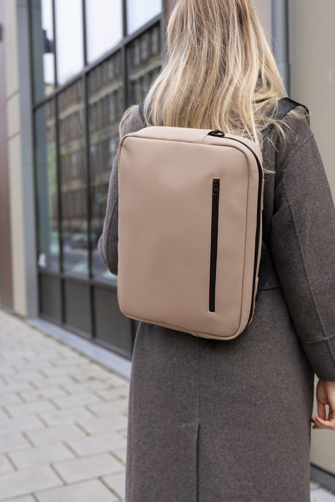 Femme portant un sac à dos beige moderne