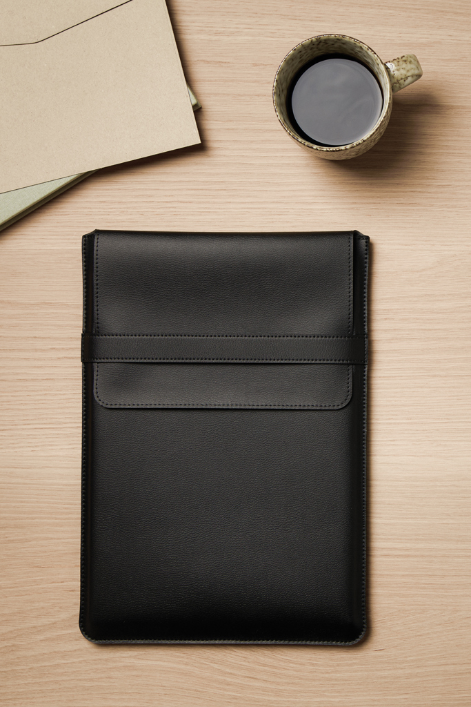 Étui noir en cuir sur bureau en bois