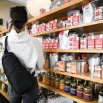 Personne choisissant des produits dans une épicerie.