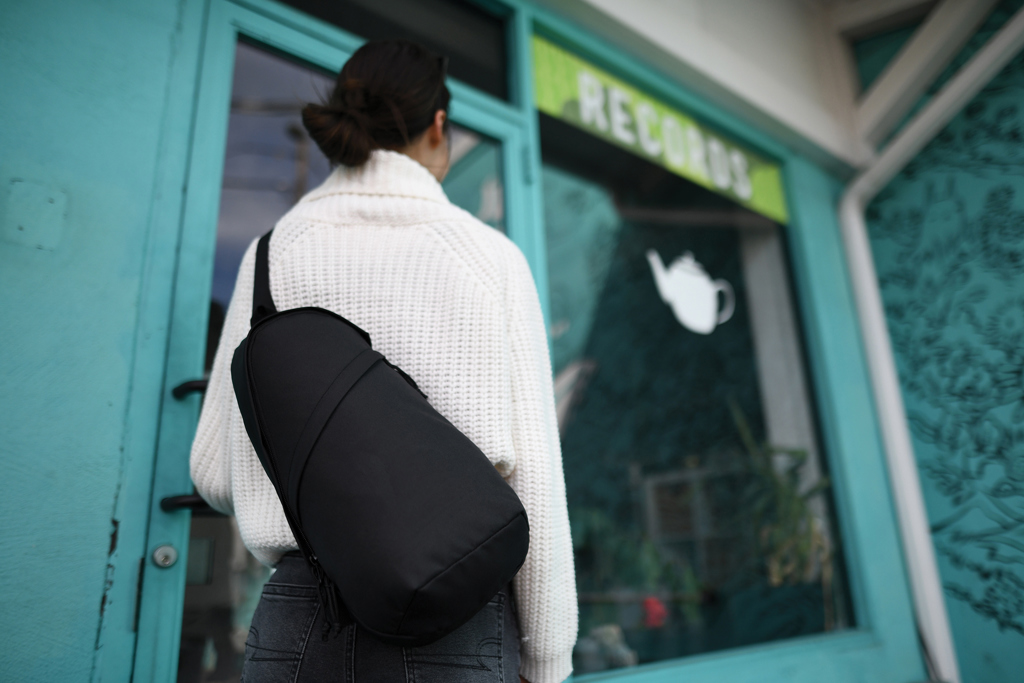 Personne entrant dans un magasin turquoise avec sac noir