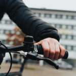 Main tenant le guidon d’un vélo en ville