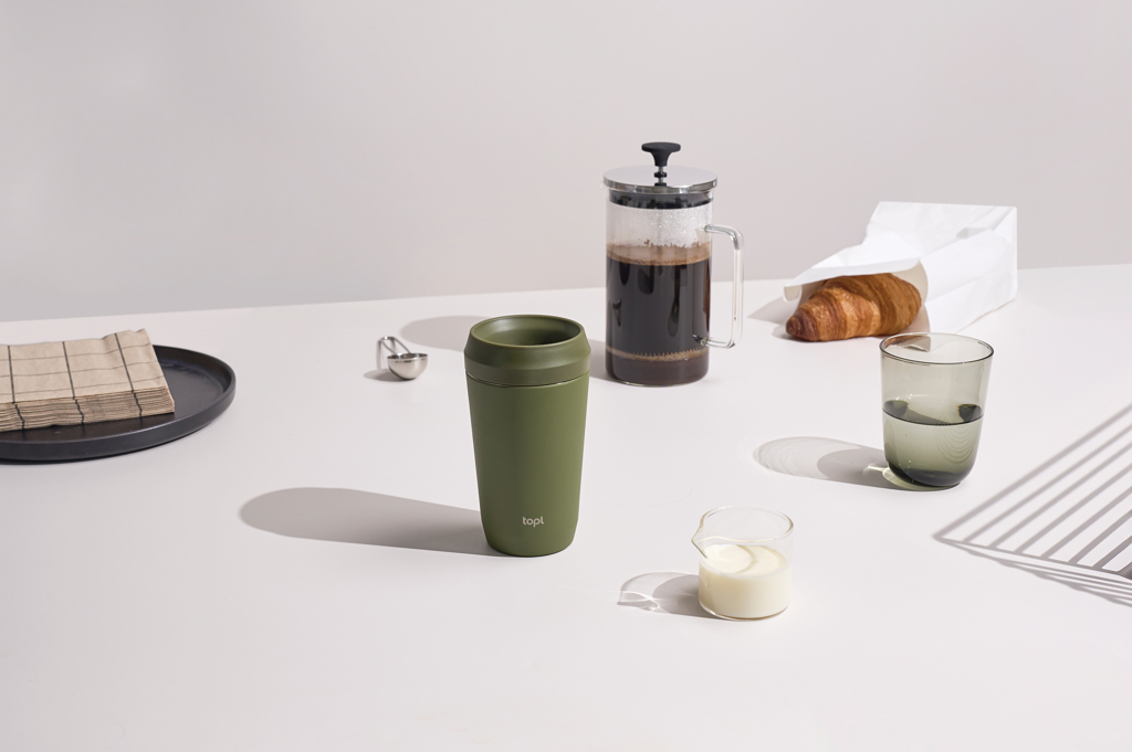 Tasse verte avec café, lait et croissant