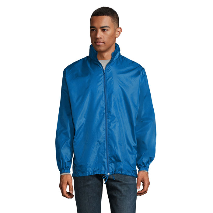 Homme portant veste bleue zippée sur fond blanc
