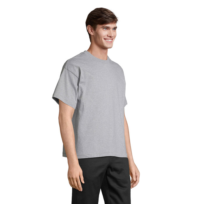 Homme portant t-shirt gris sur fond neutre