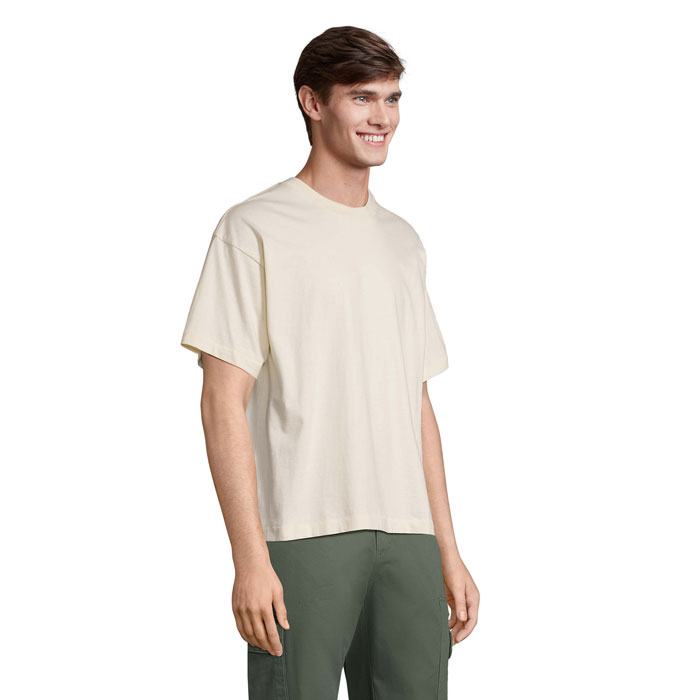Homme souriant en t-shirt beige et pantalon vert