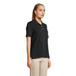 Femme portant un polo noir et pantalon beige