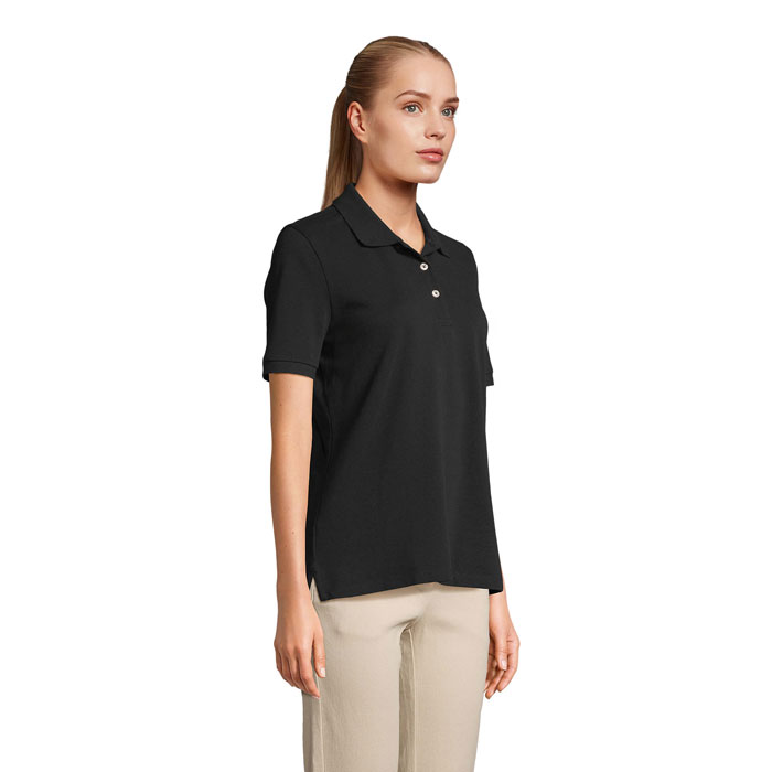Femme portant un polo noir et pantalon beige