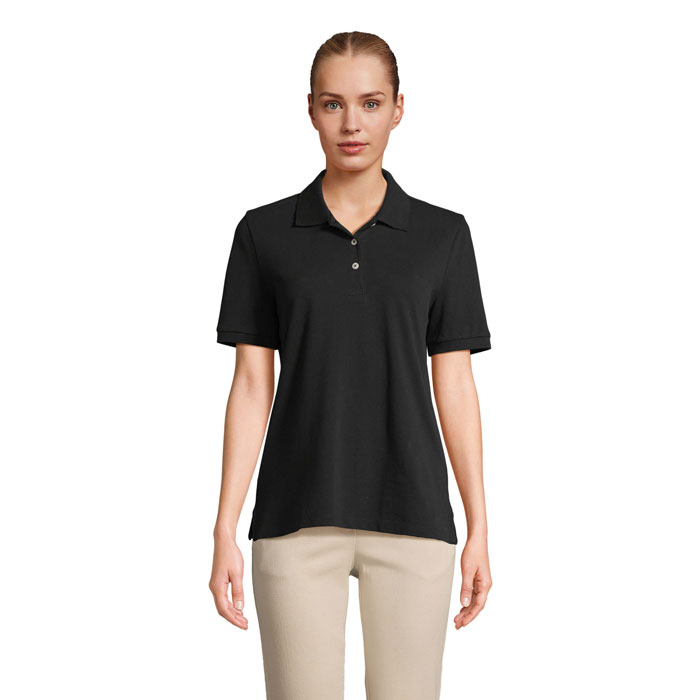 Femme portant un polo noir et pantalon beige