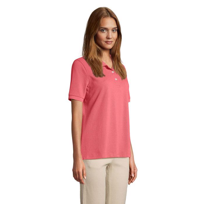 Femme portant polo rose et pantalon beige