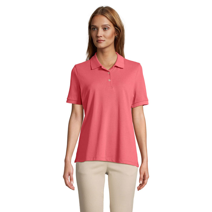 Femme portant polo rose et pantalon beige