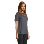 Femme portant polo gris sur fond neutre