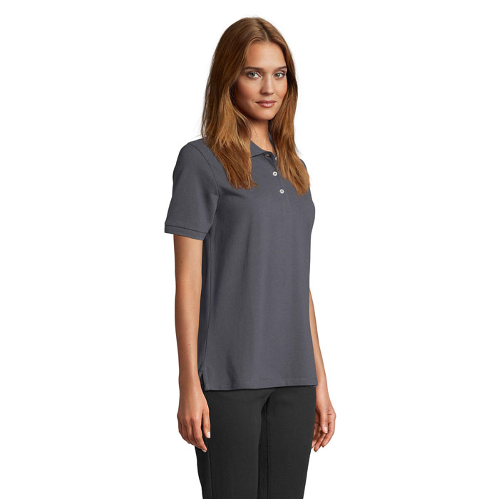 Femme portant polo gris sur fond neutre