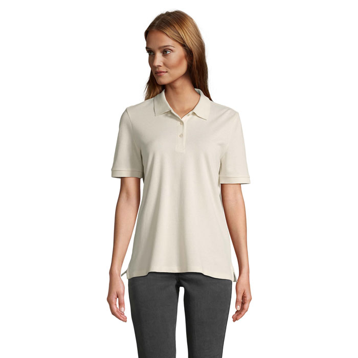 Femme portant polo beige sur fond neutre