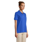 Femme portant polo bleu et pantalon beige