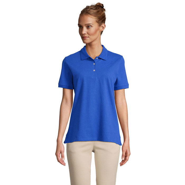 Femme portant polo bleu et pantalon beige