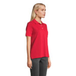 Femme portant polo rouge sur fond neutre