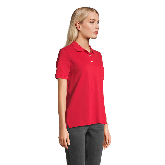 Femme portant polo rouge sur fond neutre
