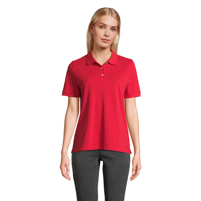 Femme portant un polo rouge sur fond neutre
