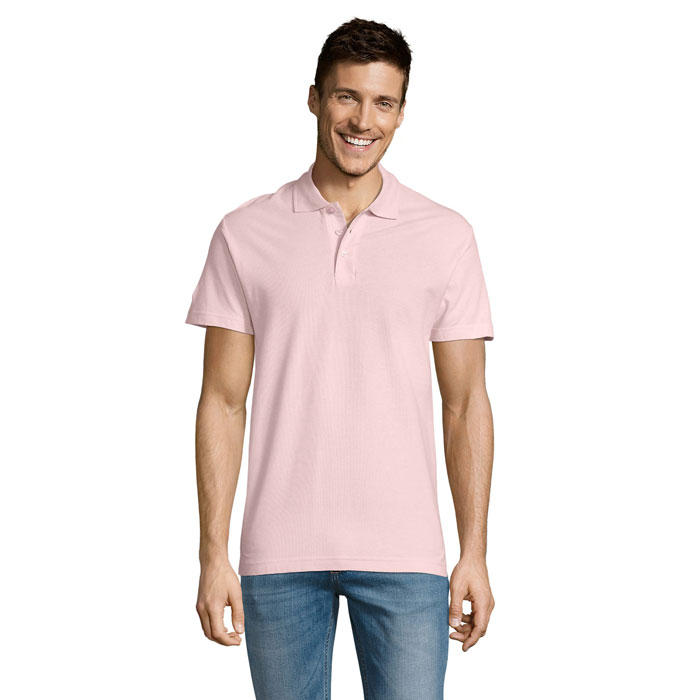 Homme souriant portant polo rose et jean