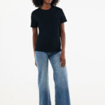 Femme portant t-shirt noir et jean large baskets blanches