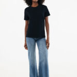 Femme en t-shirt noir et jean large baskets blanches