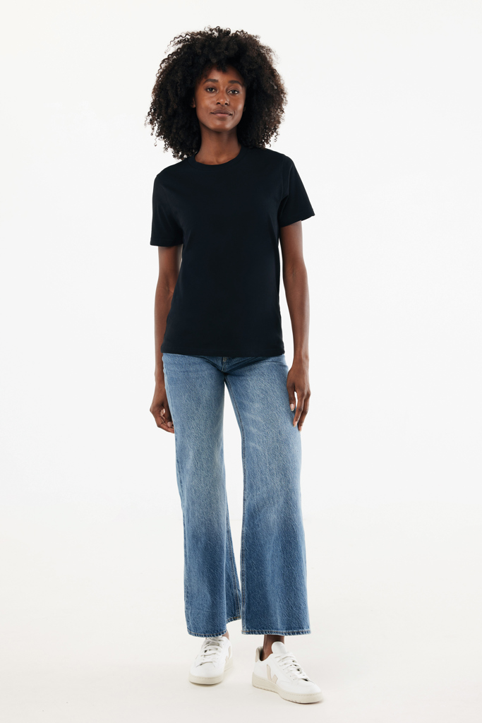 Femme en t-shirt noir et jean large baskets blanches