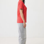 Femme de profil en t-shirt rouge et jean gris clair