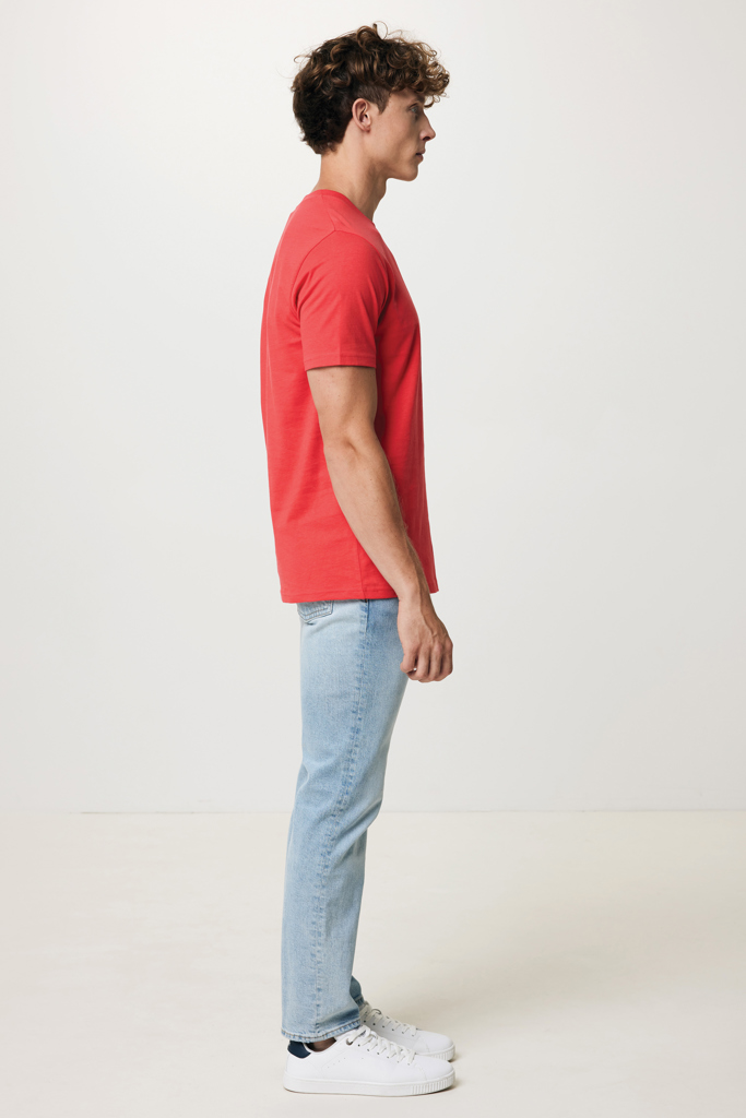 Homme en profil portant t-shirt rouge et jean