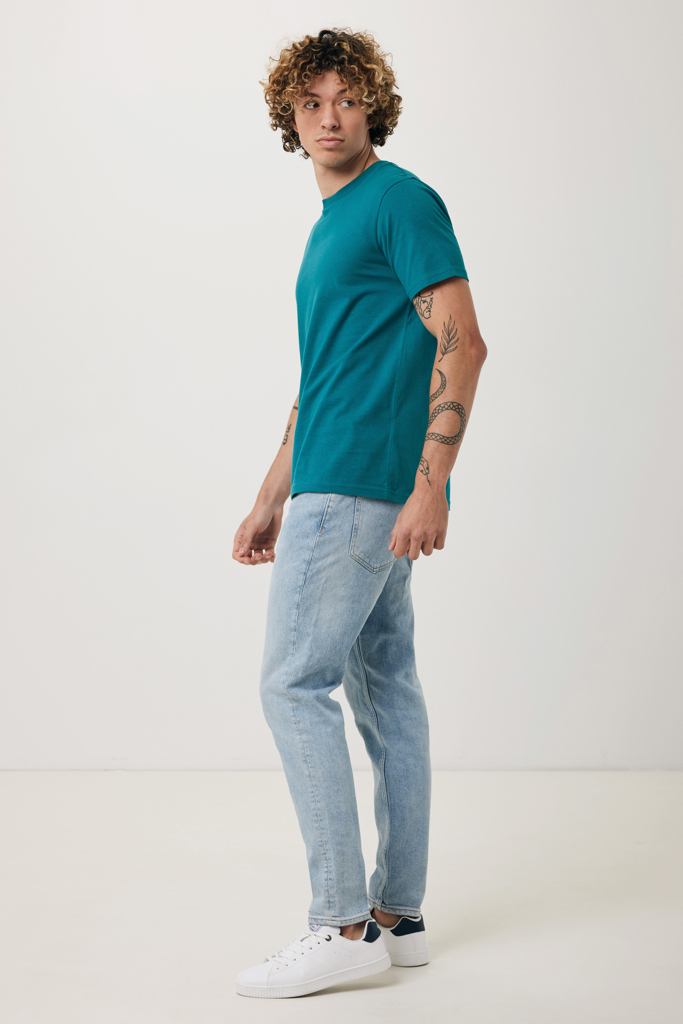 Homme en t-shirt vert et jean clair