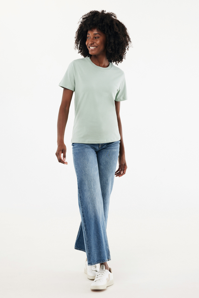 Femme souriante en t-shirt vert et jean
