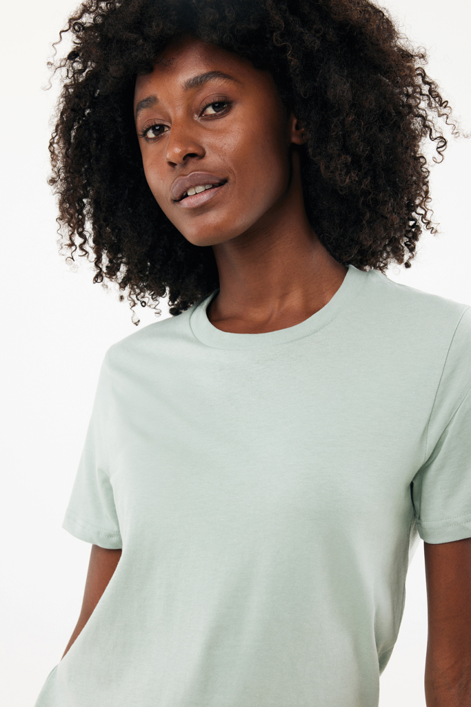 Femme aux cheveux bouclés portant t-shirt vert clair