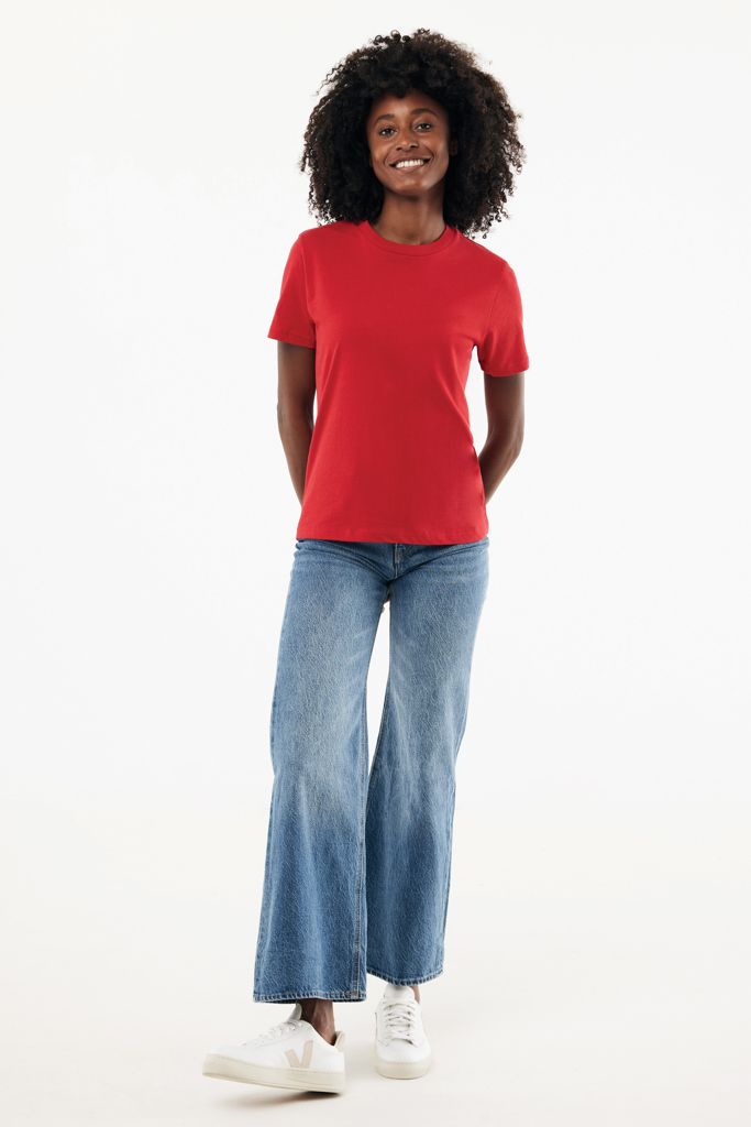 Femme souriante en t-shirt rouge et jean large